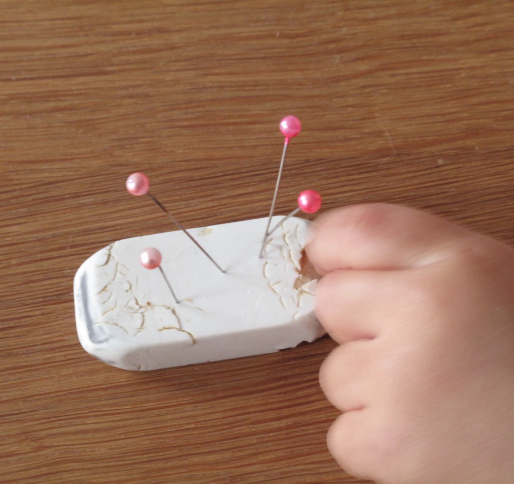 Dressmaker pins into an eraser