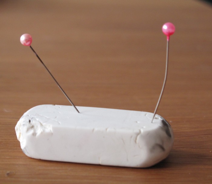 Dressmaker pins into an eraser